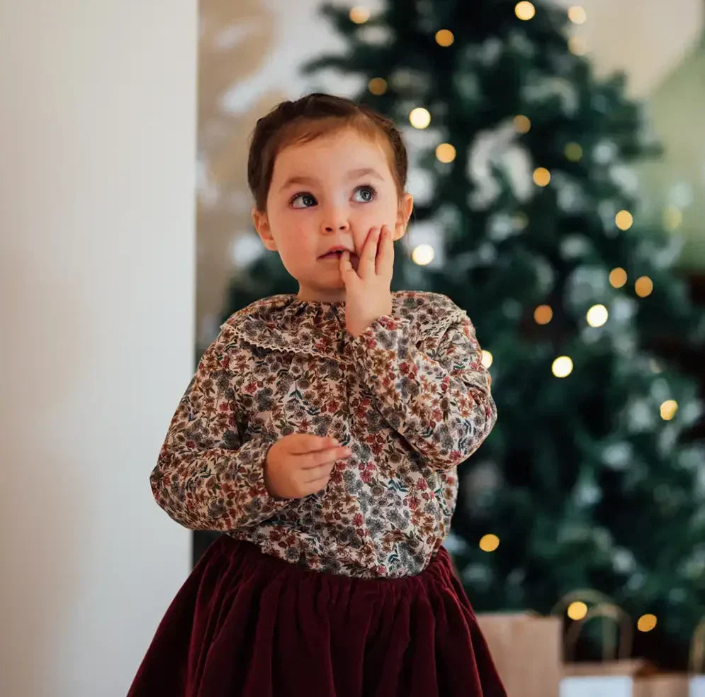 Petite fille en jupe velours bordeaux, tenue de fête Noël élégante et confortable