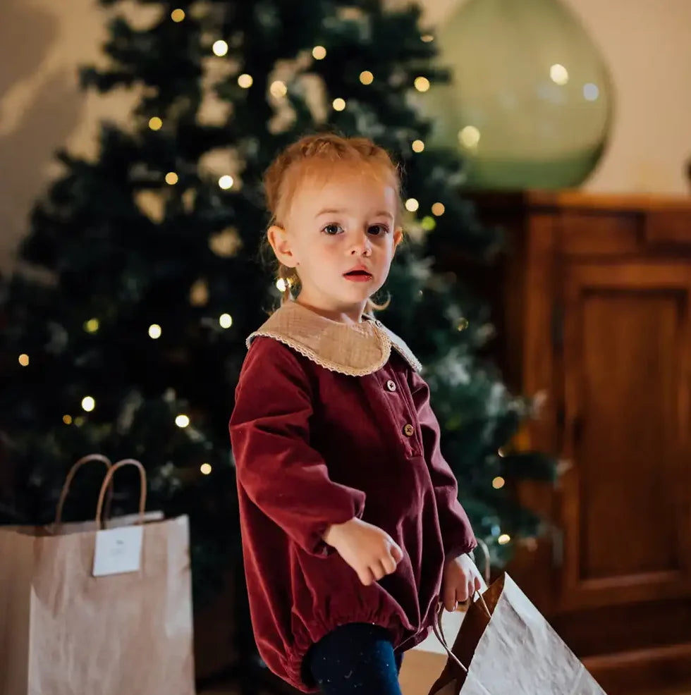 Bébé en barboteuse velours rouge avec détails en dentelle, tenue de Noël confortable et chic