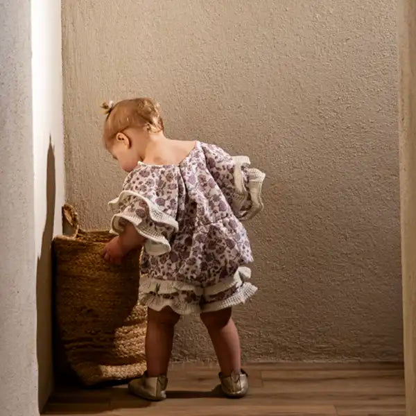 Short bébé en coton bio, tissu fleuri violet. Volants en nid d'abeille écru